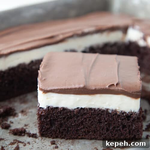 slice of ding dong cake in a cake pan with more ding dong cake in the pan.