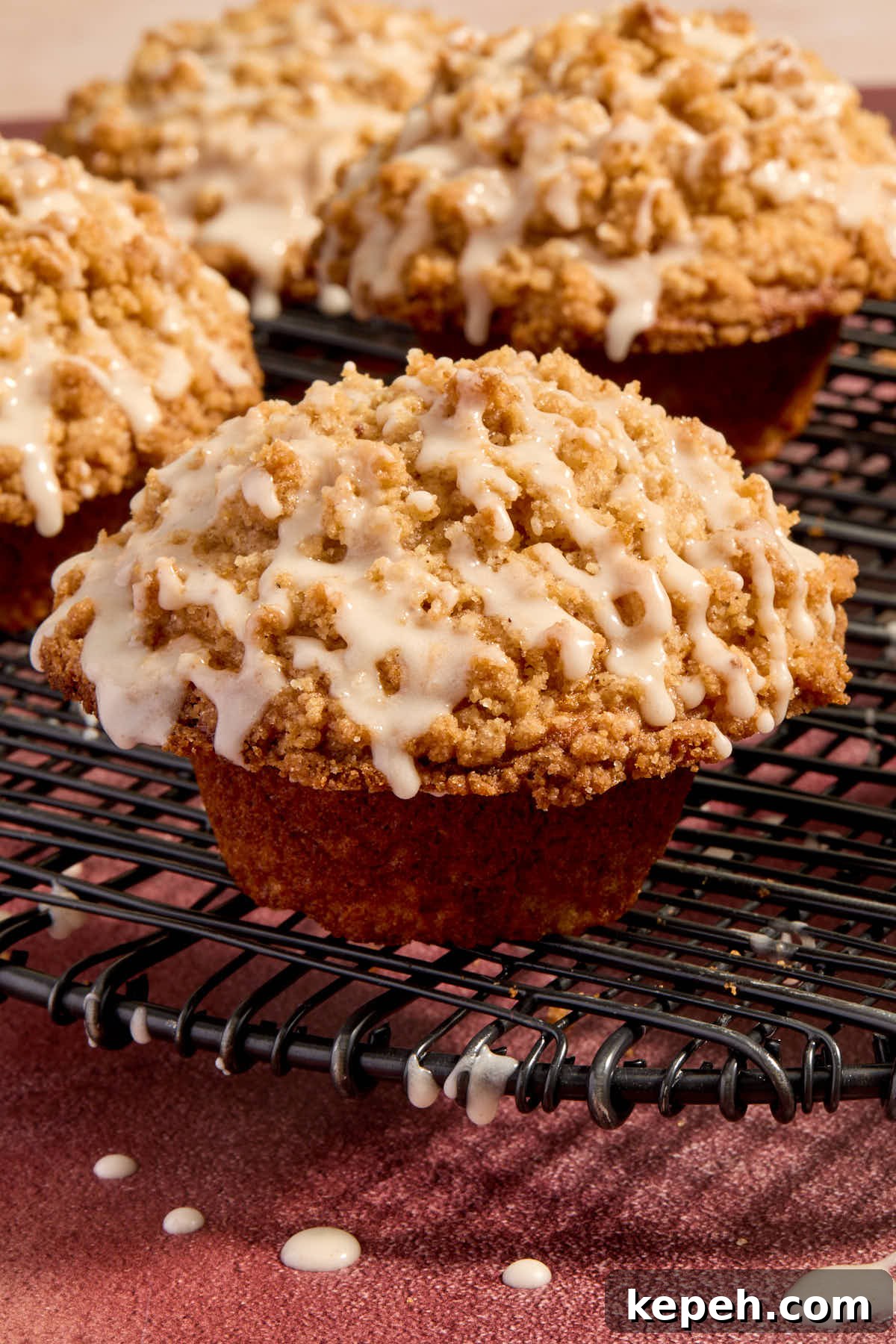 Spiced Eggnog Muffins with Streusel and Eggnog Glaze Recipe 2 Close up side view of an eggnog muffin with streusel and eggnog glaze on top.