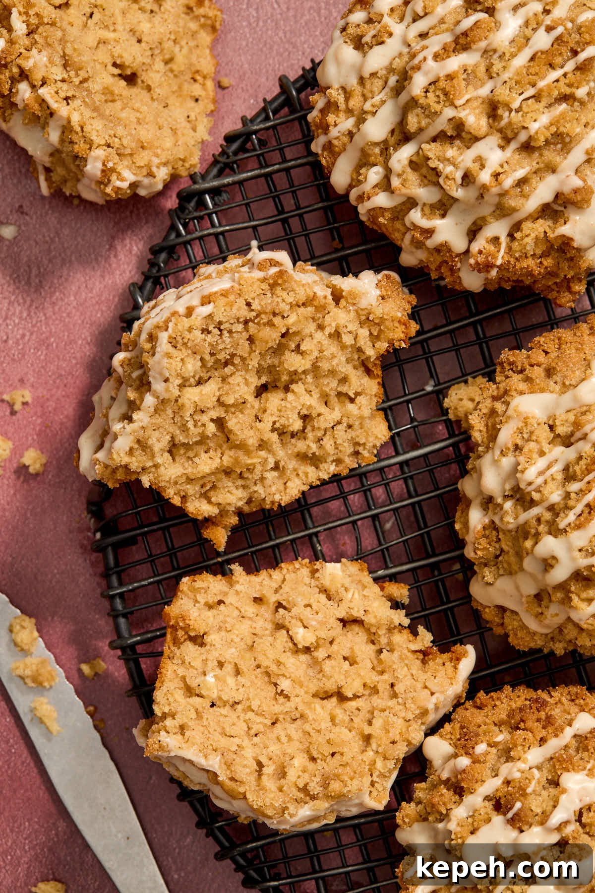Spiced Eggnog Muffins with Streusel and Eggnog Glaze Recipe 15 Overhead shot of eggnog muffins on a wire rack with one cut in half.