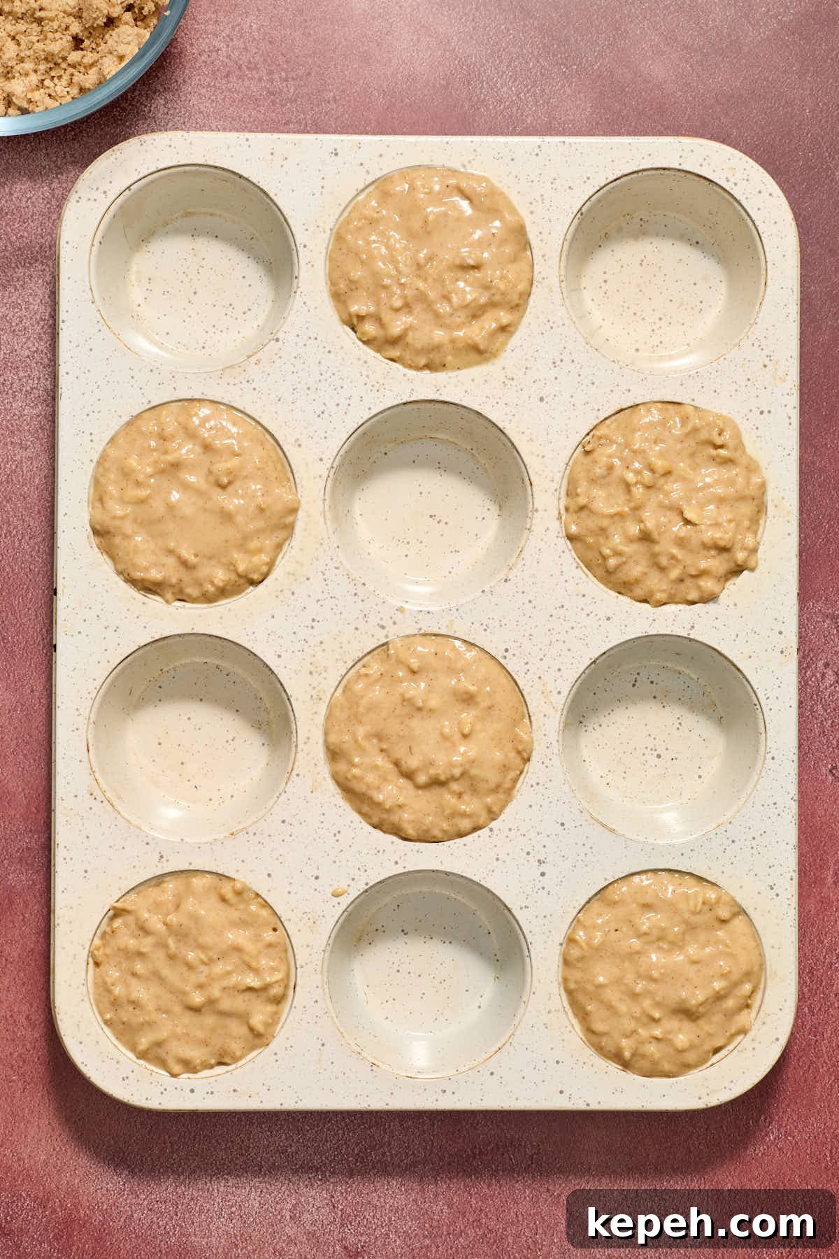 Spiced Eggnog Muffins with Streusel and Eggnog Glaze Recipe 10 Batter spooned into every second muffin cup in a 12 cup muffin tin.
