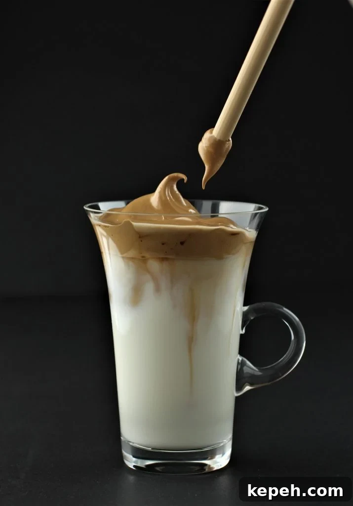 Dalgona Whipped Coffee Recipe: Creamy Instant Coffee at Home 3 use a straw to stir up the dalgona coffee