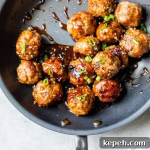 Sticky Teriyaki Pork Meatballs with Ginger and Sesame 12 cooked meatballs in a skillet with an asian sauce
