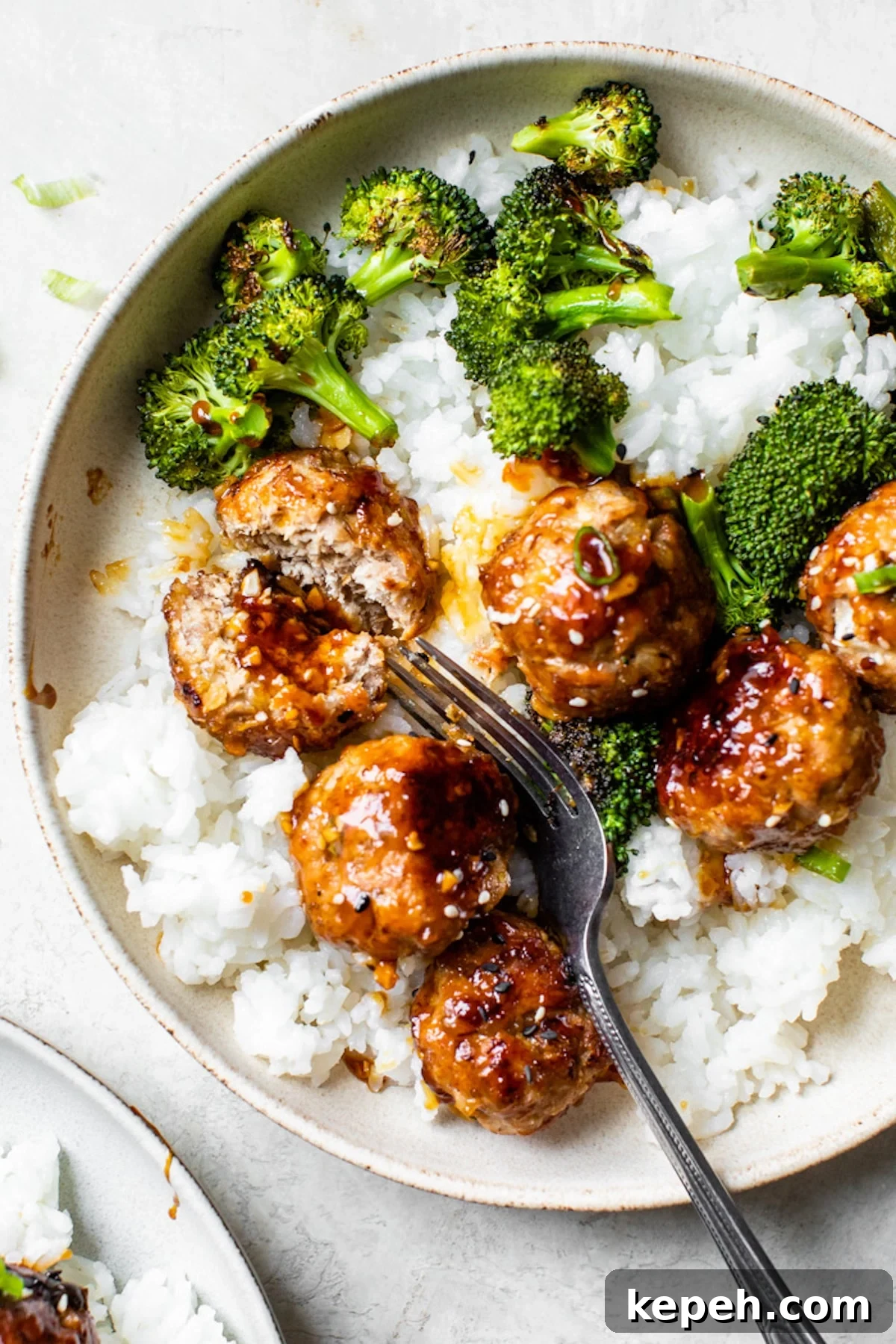 Sticky Teriyaki Pork Meatballs with Ginger and Sesame 8 a bowl of white rice topped with broccoli and meatballs