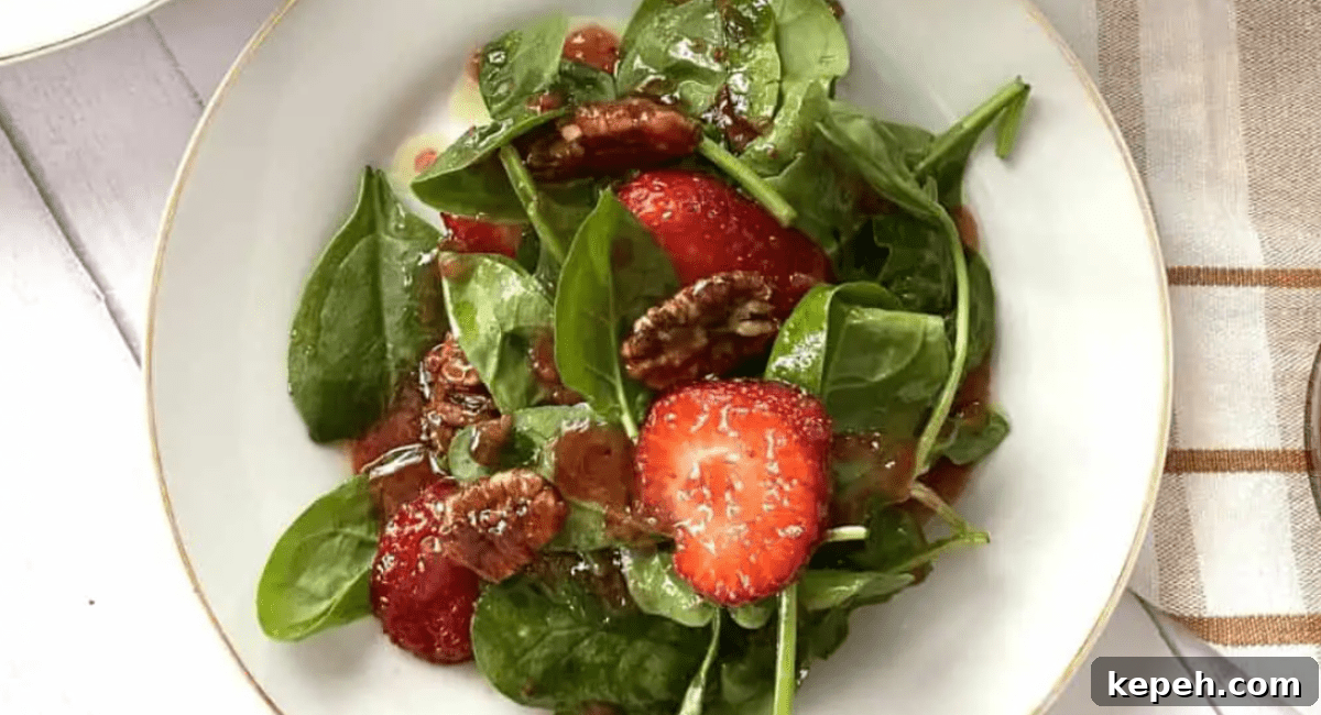 Overhead image of spinach salad with strawberry vinaigrette.
