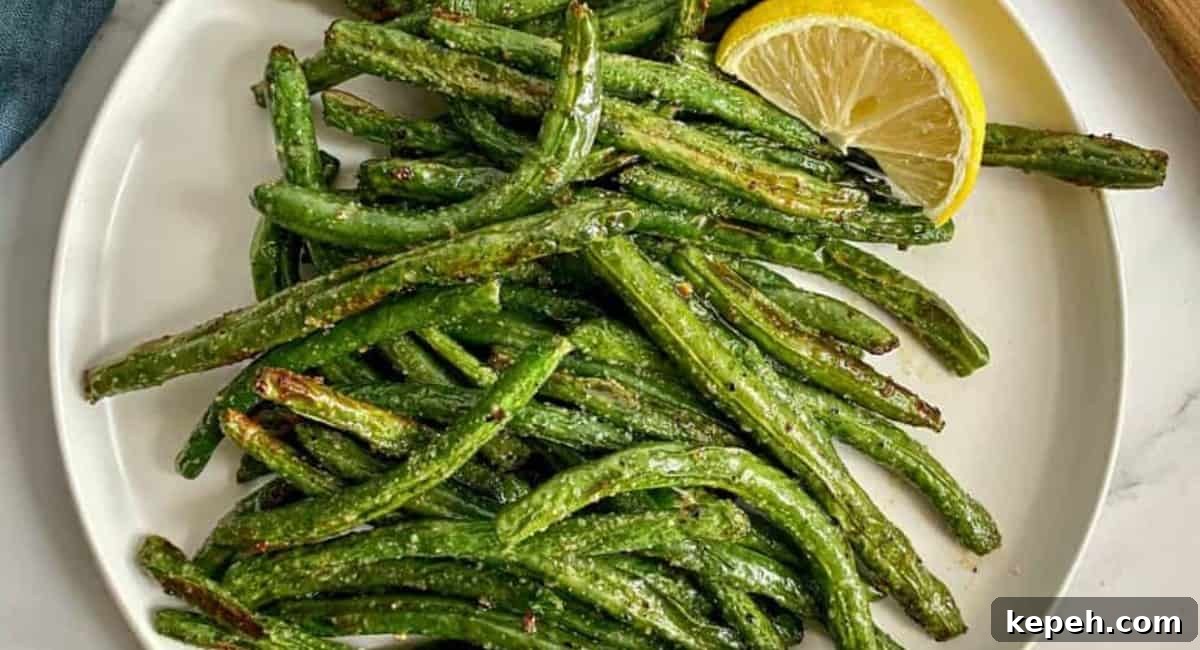 Overhead image of air fryer green beans on white dish.