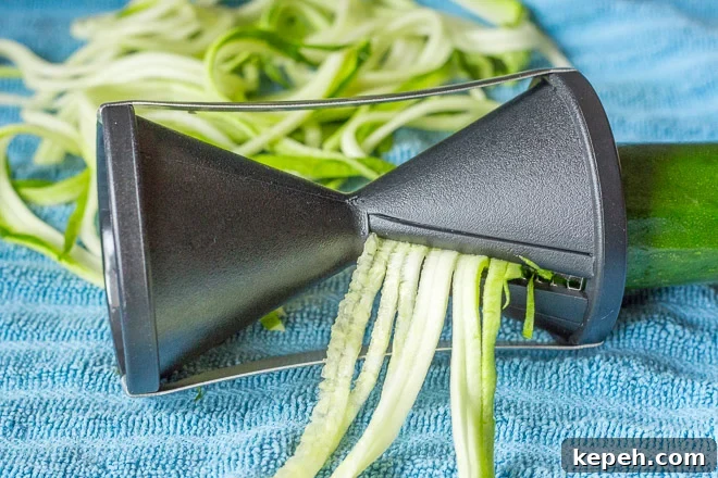 spiralizing zuchhini for zoodles on a blue towel