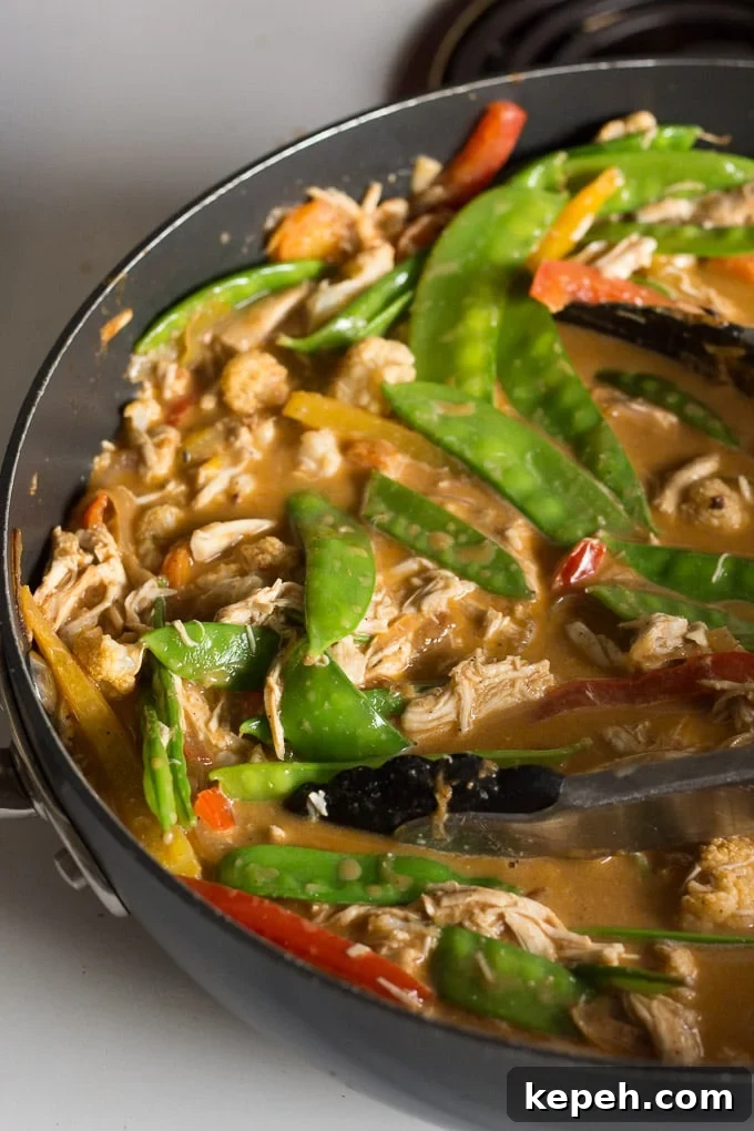 chicken curry zoodle ingredients in a pan with tongs