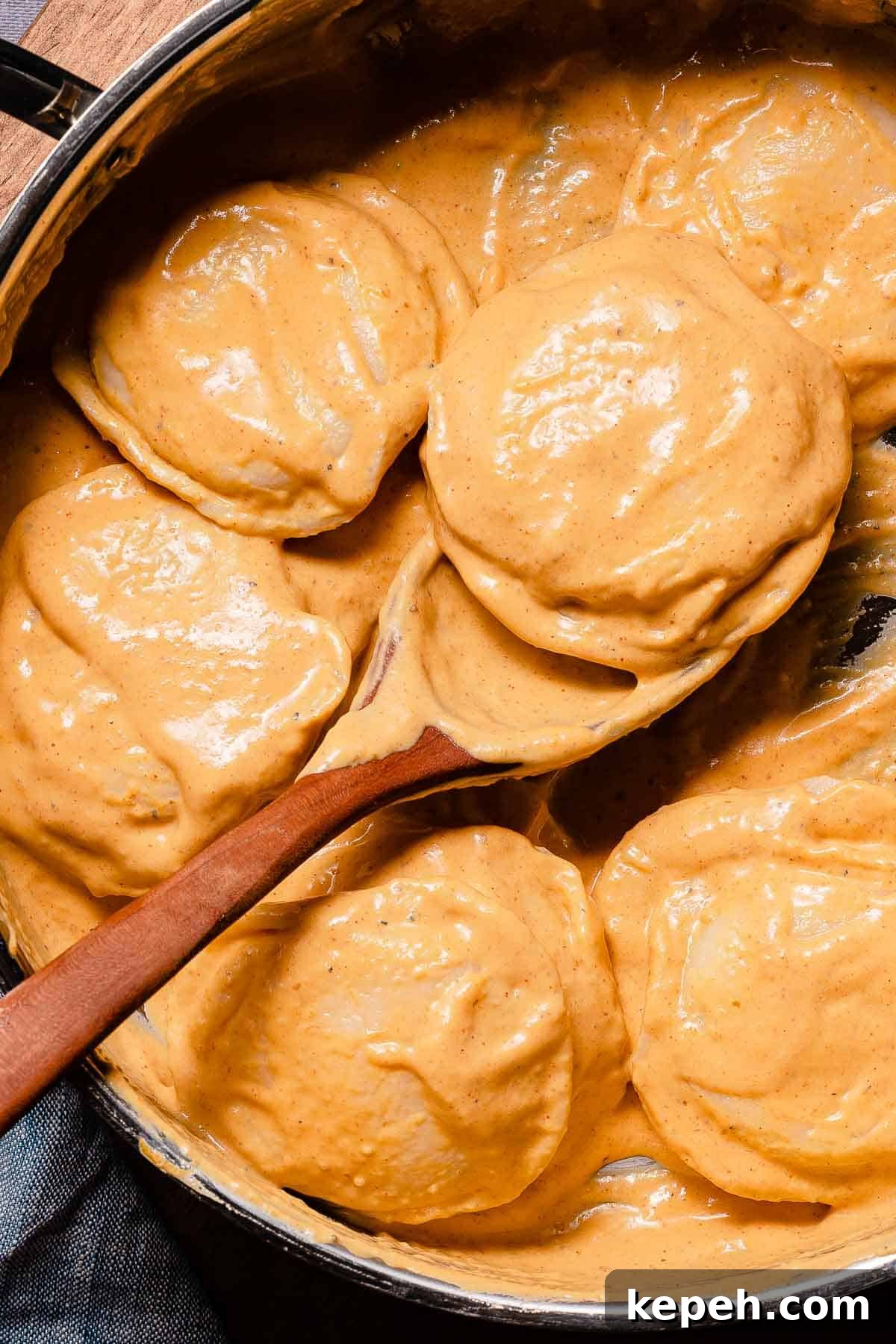 wooden spoon scooping ravioli out of pan