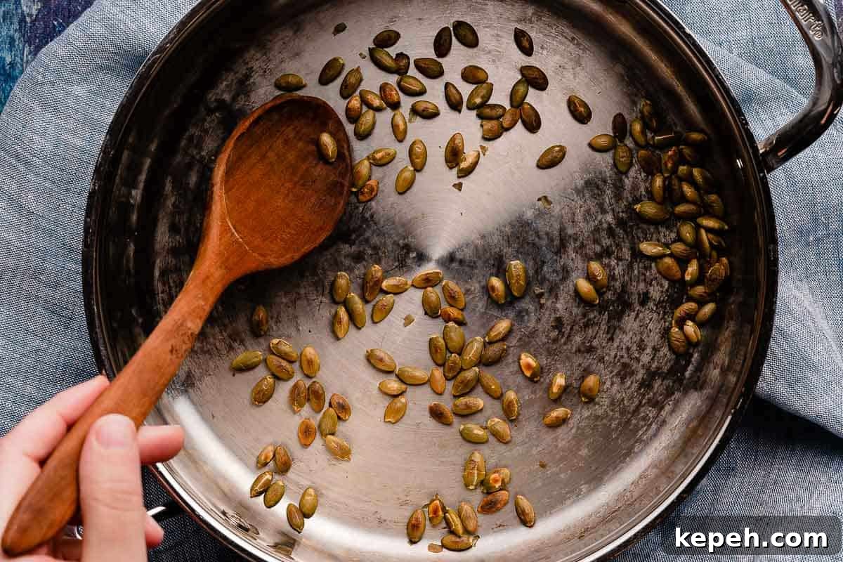 pumpkin seeds in pan with spoon