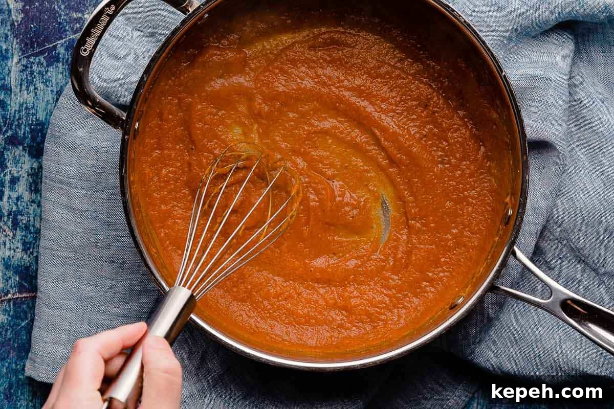 pumpkin and broth whisked together in pan