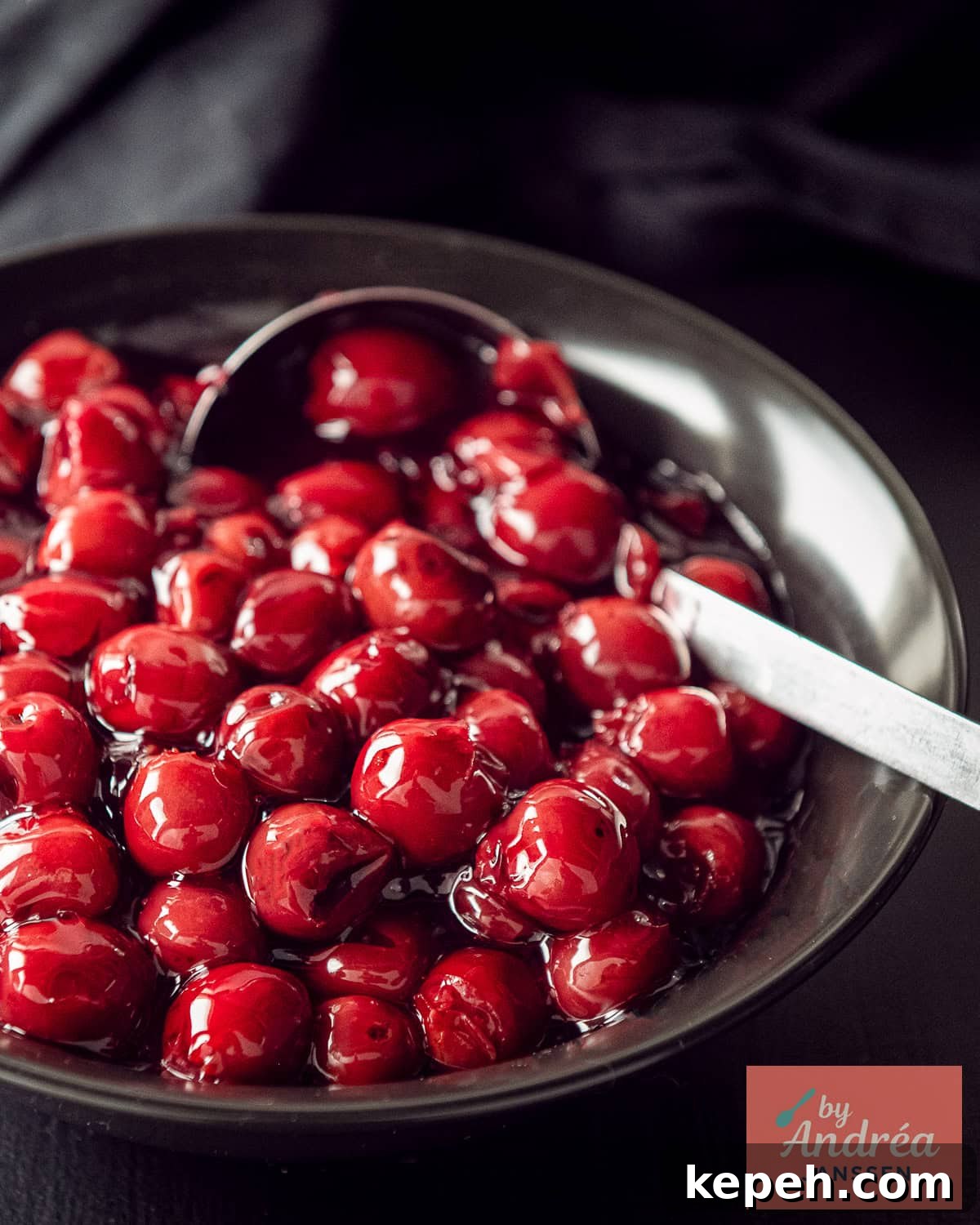 A black bowl with cherry filling for pie.