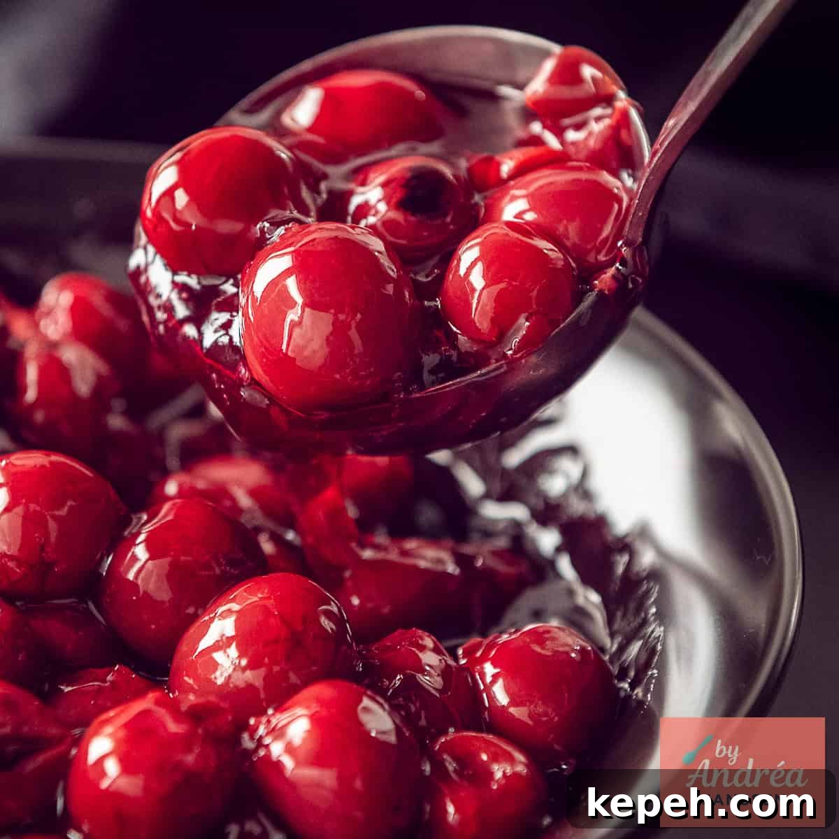 A square photo of a bowl of cherry pie filling being scooped out.