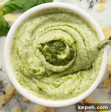 overhead shot of pesto mayo in white pot surround by garnish