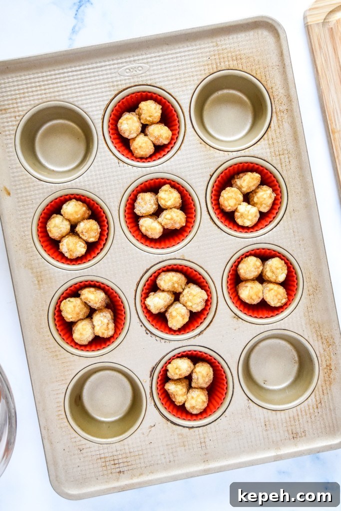 Tater Tot Crust Baked Egg Cups: Crispy Potato Breakfast Cups 6 tater tots in a muffin pan before baking.