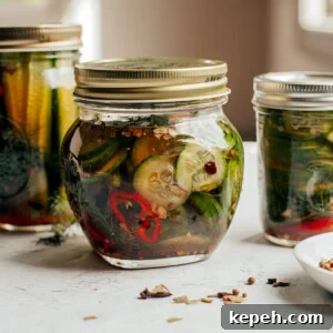 Differently sized jars of refrigerator pickles sitting on countertop.