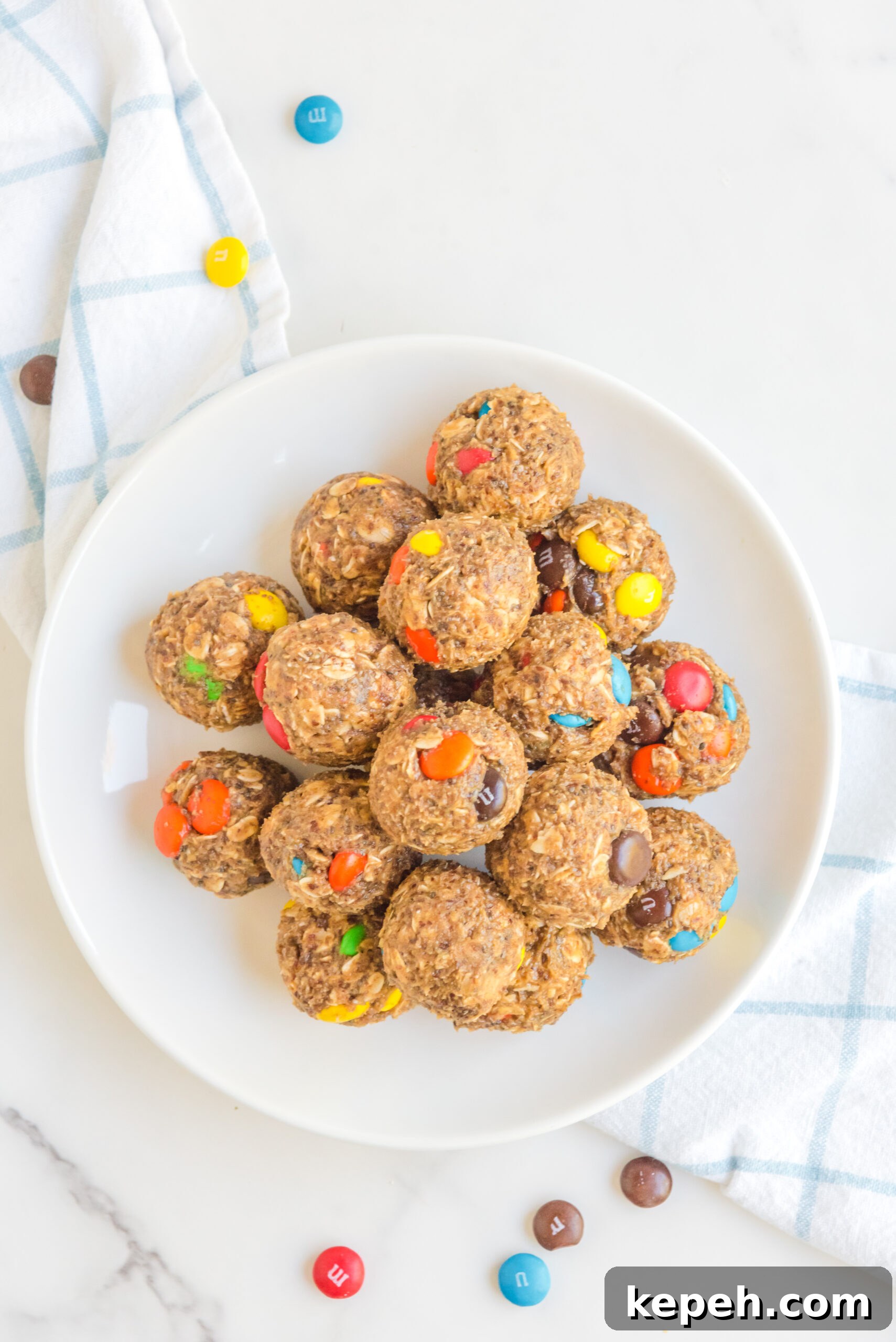 No-Bake M&M Energy Bites: Chocolate Peanut Butter Snack Balls 15 Overhead view of No Bake M&M Energy Balls in a white dish.