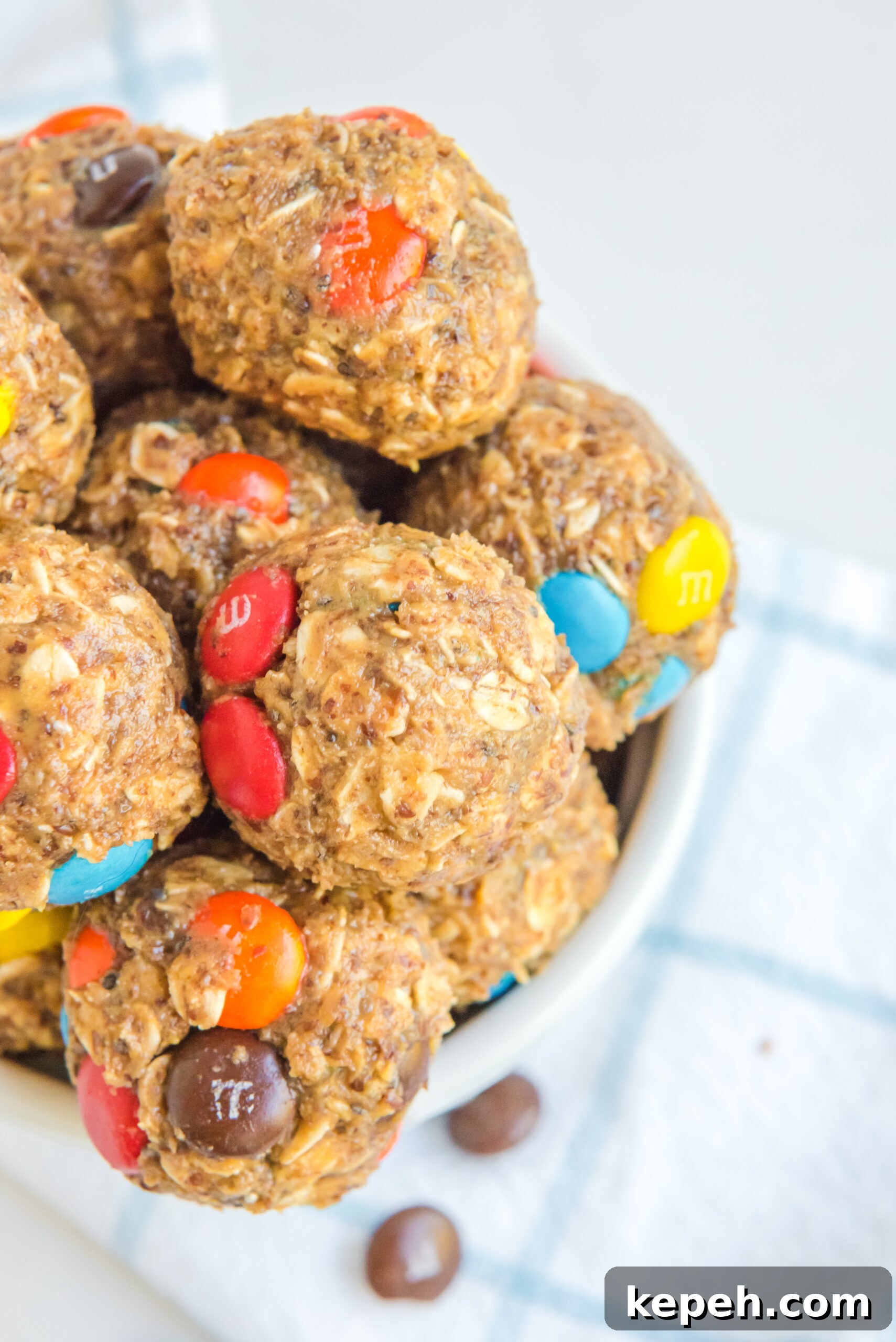 No-Bake M&M Energy Bites: Chocolate Peanut Butter Snack Balls 4 Close up view of No Bake M&M Energy balls in a white bowl.