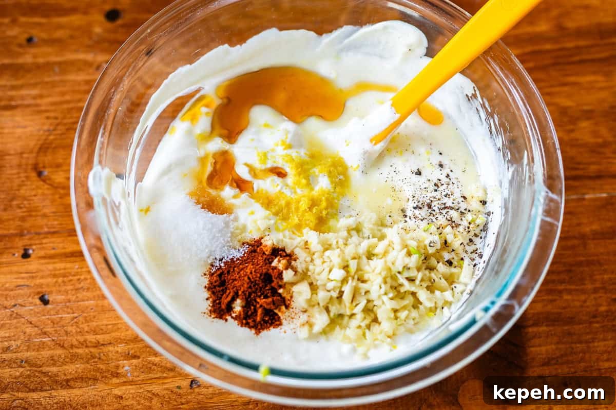 Authentic Chicken Shawarma Recipe: Juicy Middle Eastern Wraps 11 white garlic sauce ingredients in bowl - mayo, greek yogurt, garlic, and spices.