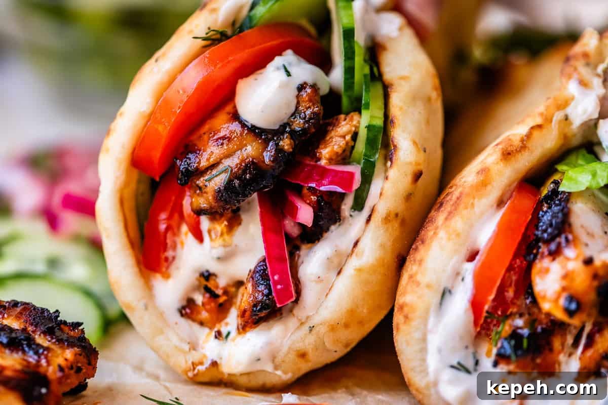 Authentic Chicken Shawarma Recipe: Juicy Middle Eastern Wraps 13 super close up image showing the juicy seared chicken, lettuce, tomato, and sauce in shawarma.
