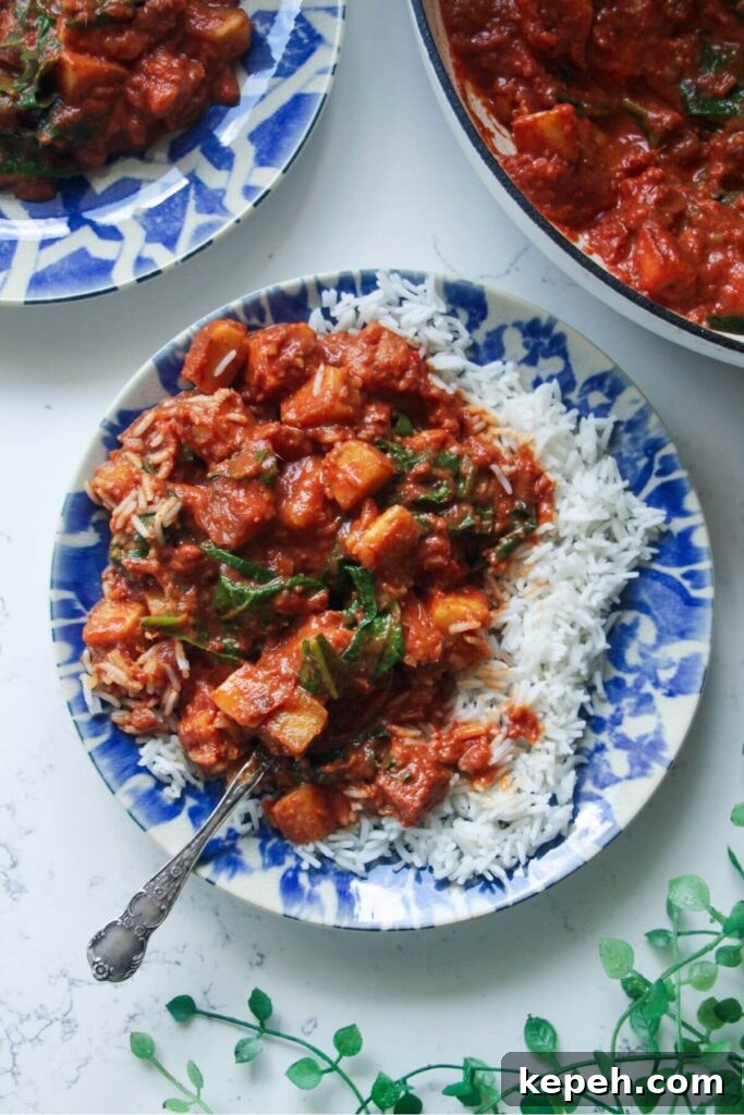Creamy halloumi curry with spinach on rice on a small plate.