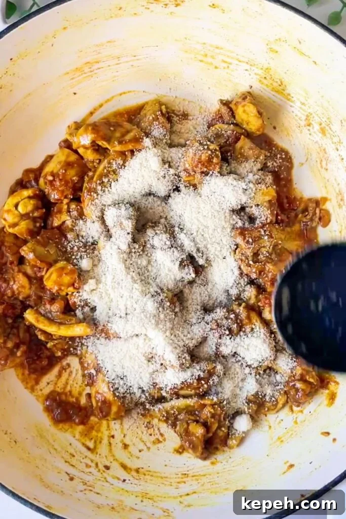 Ground almonds scattered on top of chicken in a pan.