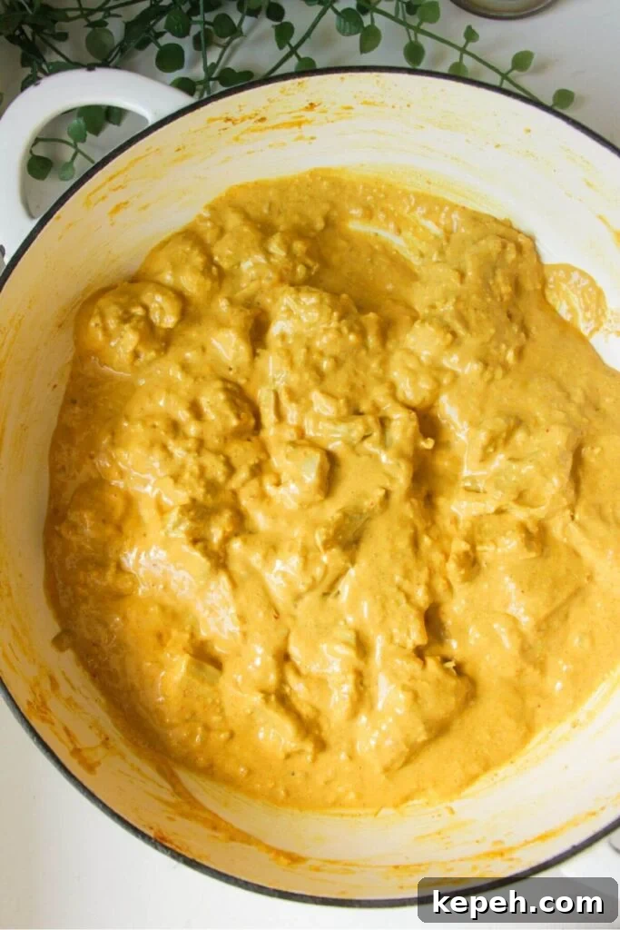 Chicken korma curry in a large pan.