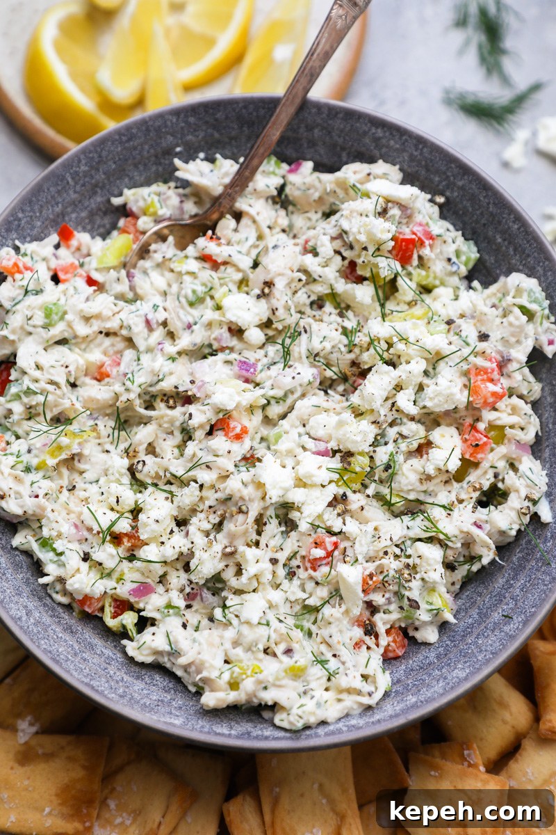 A close up photo of feta chicken salad sprinkled with fresh dill and extra feta cheese