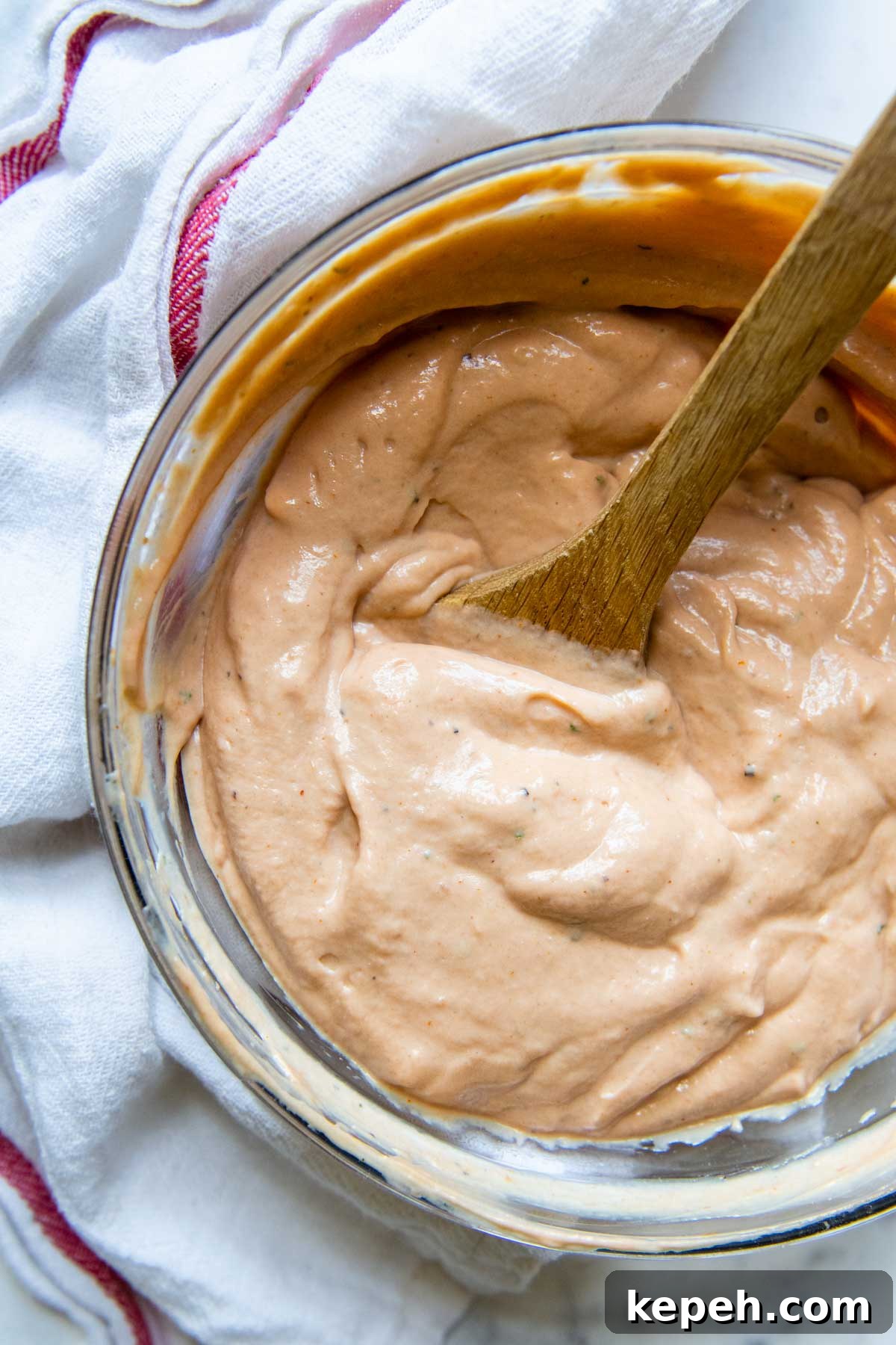 5-Minute BBQ Ranch Sauce & Dressing Recipe 2 overhead shot of barbeque ranch with a wooden spoon in bowl.