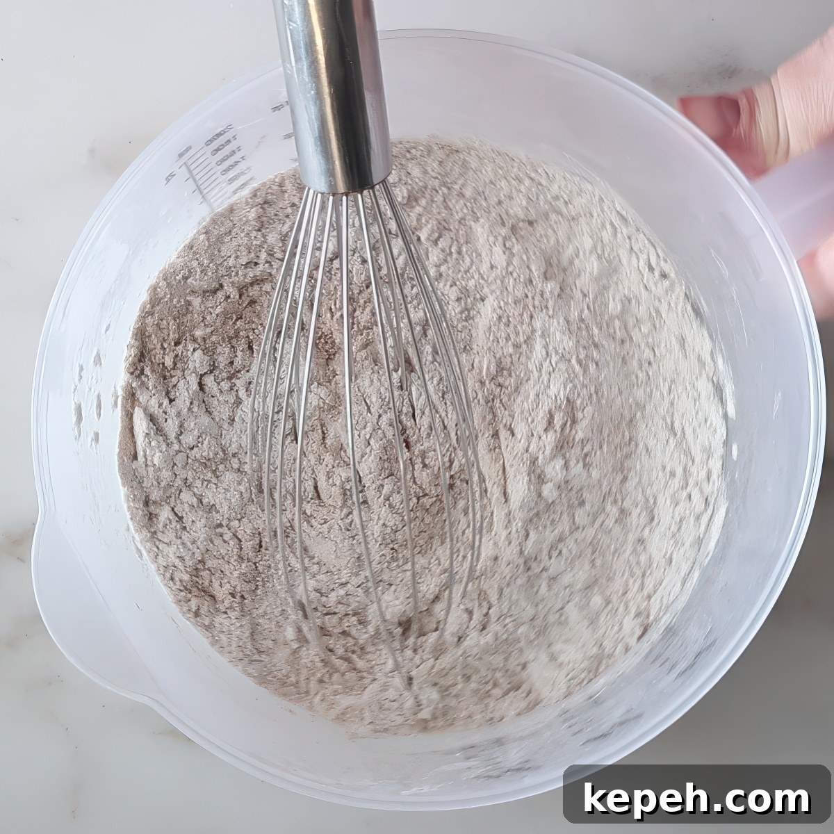 Gluten-Free Gingerbread Loaf Recipe That Delights 5 whisk in a plastic jug filled with dry ingredients.