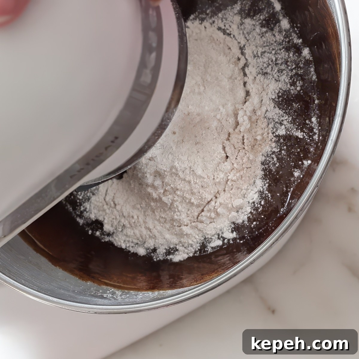Gluten-Free Gingerbread Loaf Recipe That Delights 7 flour on top of dark batter in stand mixer bowl.