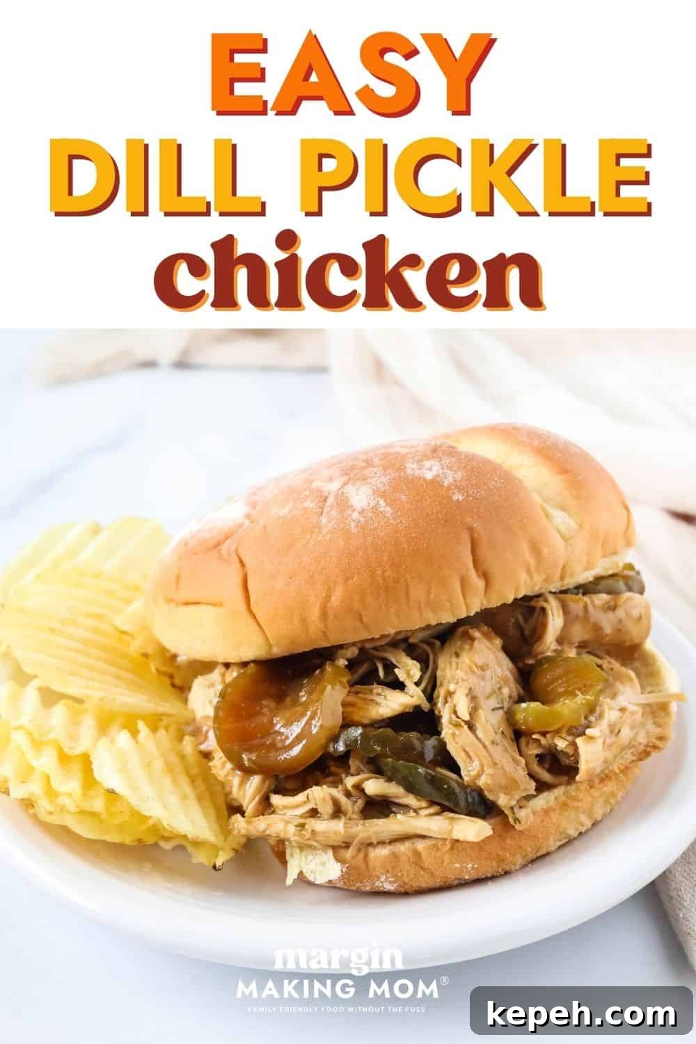 Dill pickle chicken on a sandwich bun, served on a white plate alongside potato chips.