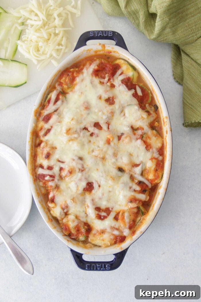 Zucchini Lasagna Roll-Ups with Ricotta & Marinara 4 Overhead picture of zucchini lasagna roll ups in a blue oval baking dish with melted mozzarella on top