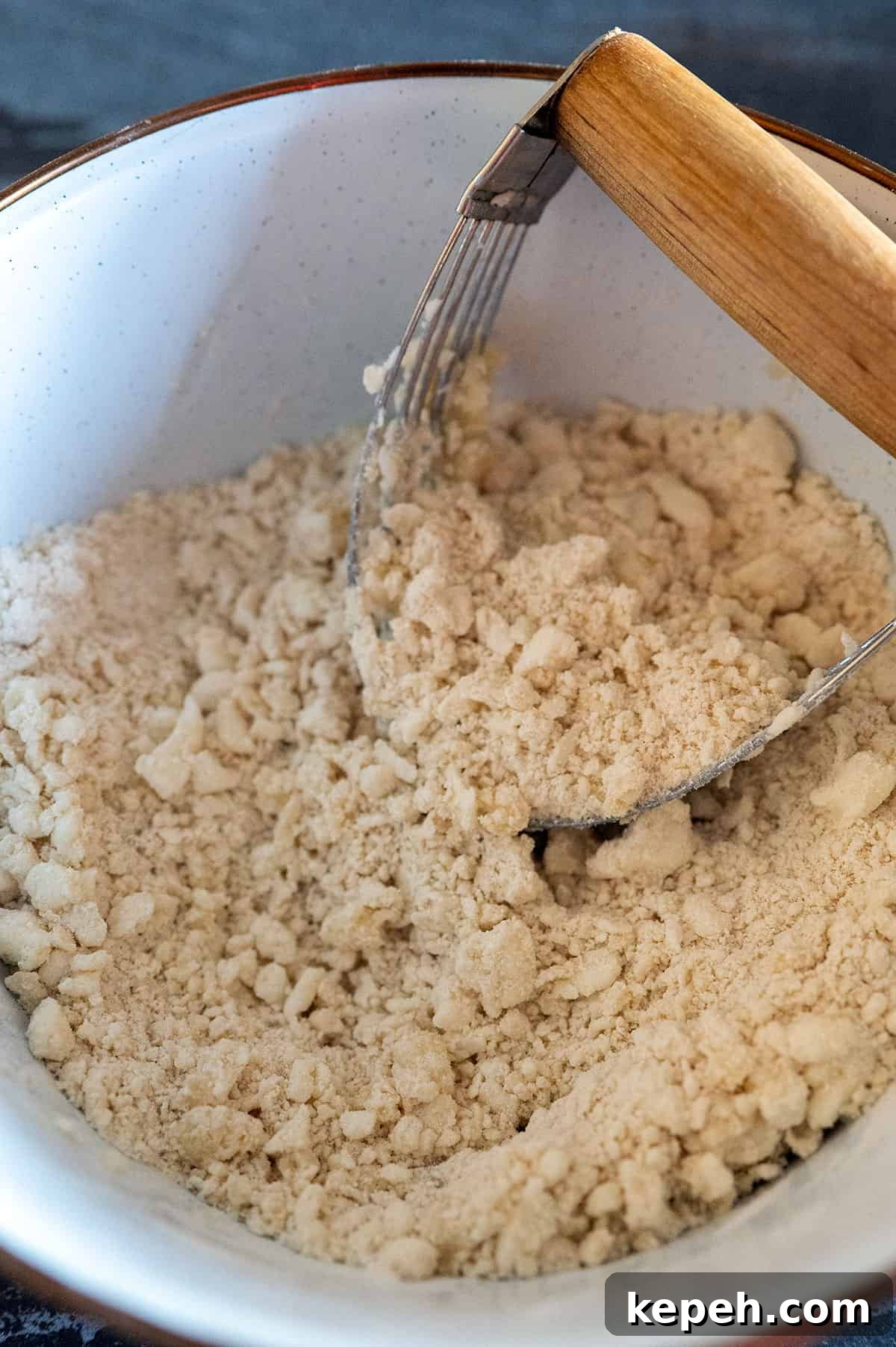 Flaky Pie Crust Recipe for Sweet and Savory Pies 5 pastry blender mixing flour and fats to create pea-size balls.