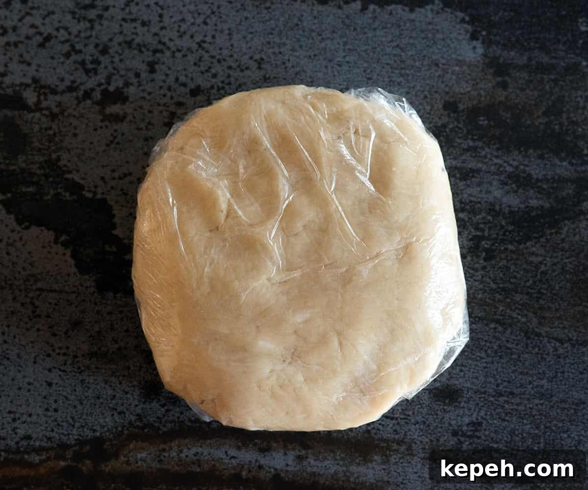 Flaky Pie Crust Recipe for Sweet and Savory Pies 7 pie crust dough shaped into a disc and wrapped in plastic.