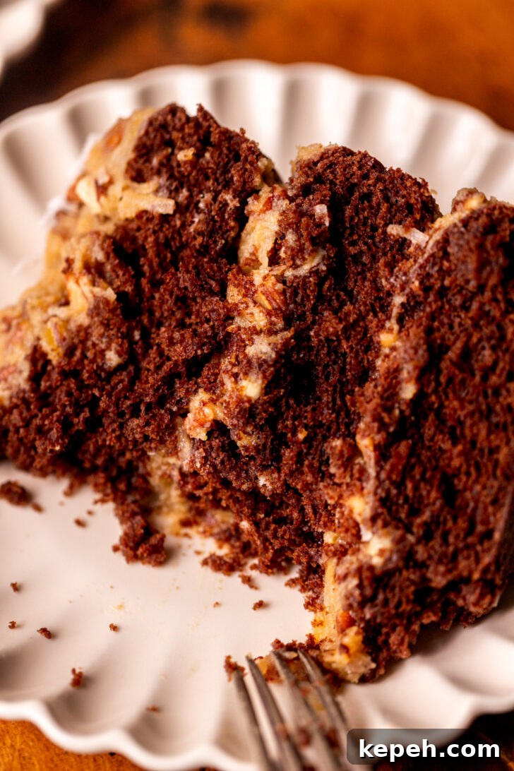 Authentic German Chocolate Cake Recipe for Decadent Dessert 11 Bite missing from a slice of cake on a plate.