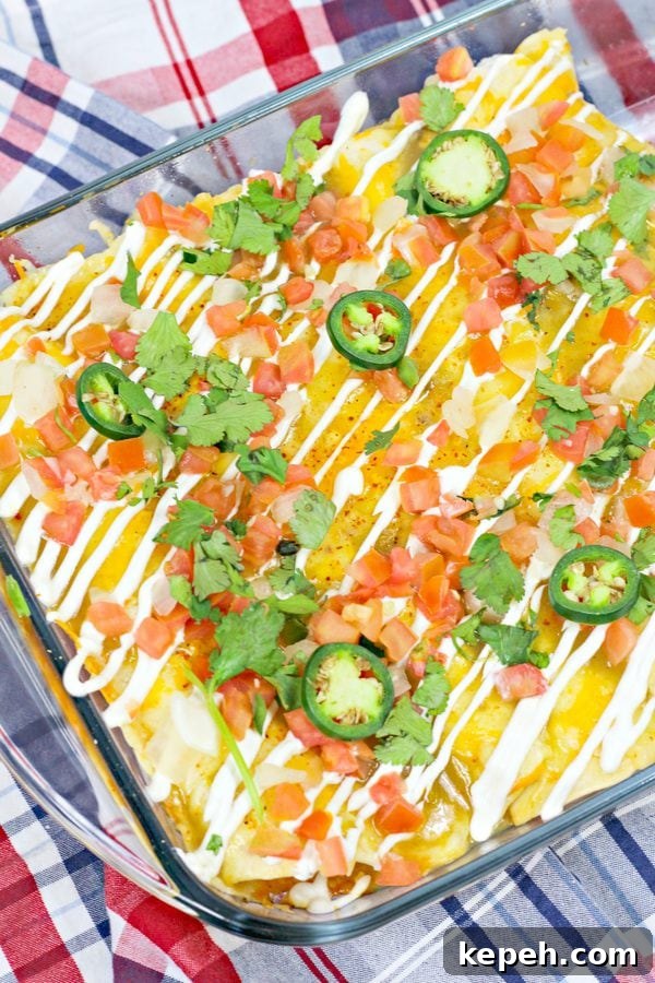 a breakfast casserole topped with tomatos, jalapenos, sour cream, and cilantro in a glass pan.