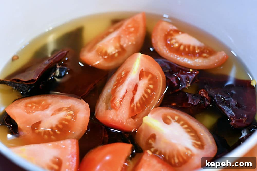 Authentic Red Tamale Sauce Recipe with Video Guide 5 24Bite: Homemade Tamale Sauce Tomatoes and Chiles simmering