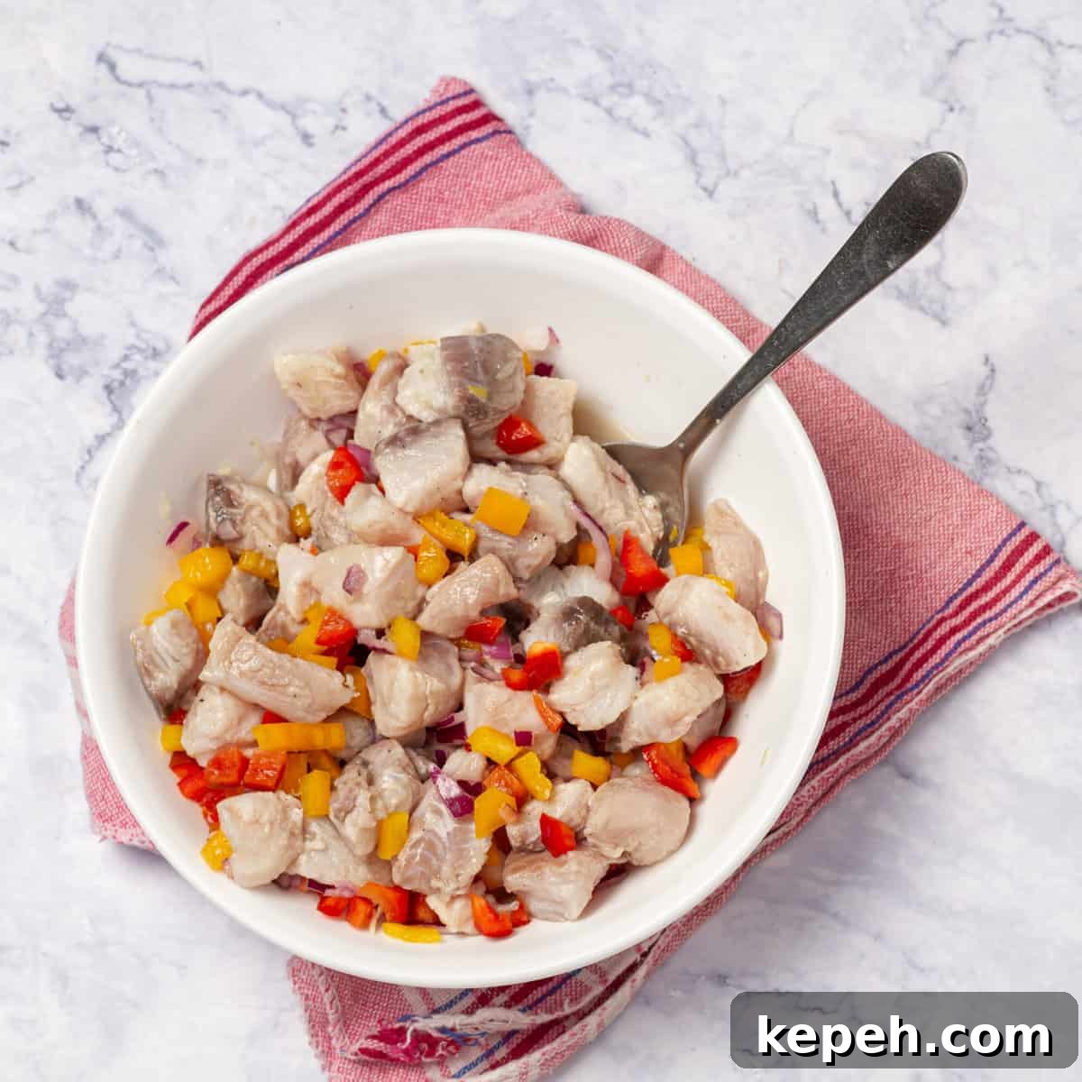 Low-Calorie Ceviche Recipe with WW Points Guide 7 The marinated fish, all bell peppers and sliced red onion combined in a large mixing bowl.