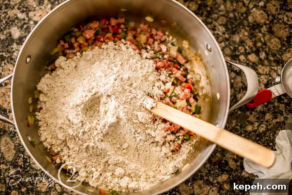 overhead view of cooked peppers, onions, and ham with dry ingredients on top