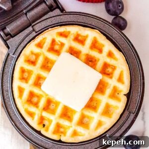 Crispy Dash Waffle Maker Recipes for Quick Breakfasts 7 The finished Dash waffle make recipe in the waffle maker with a pad of butter on top of the waffle.