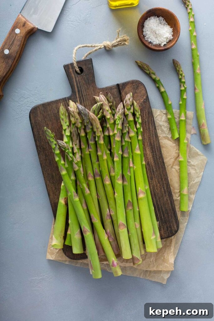 How to Store Asparagus for Maximum Freshness 3 fresh asparagus set on a cutting board.