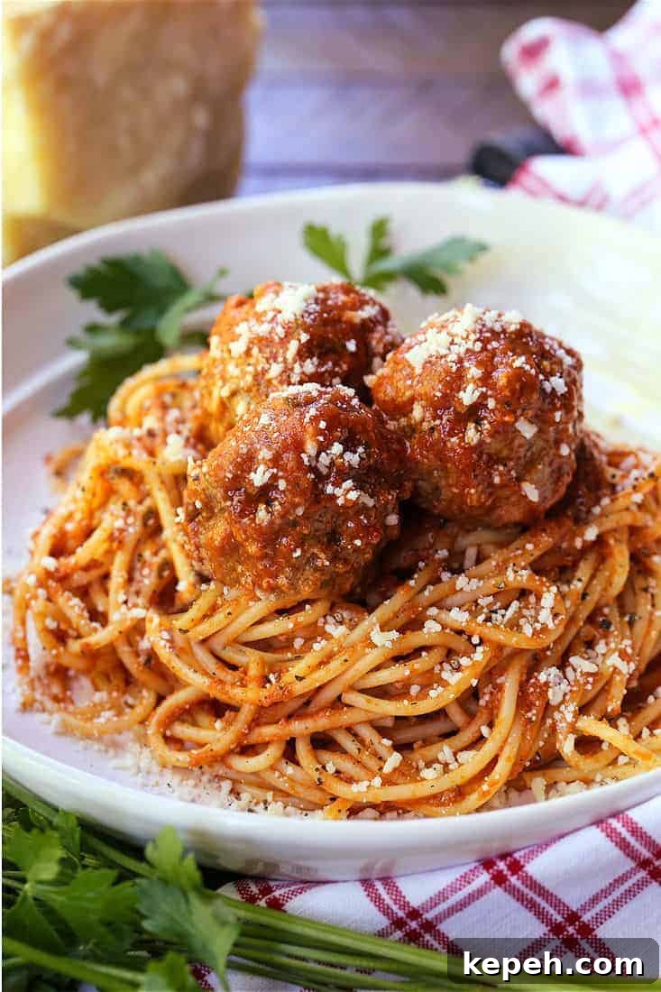 Slow Cooker Meatballs—comfort food that’s easy on busy nights meatballs and sauce recipe served on top of spaghetti