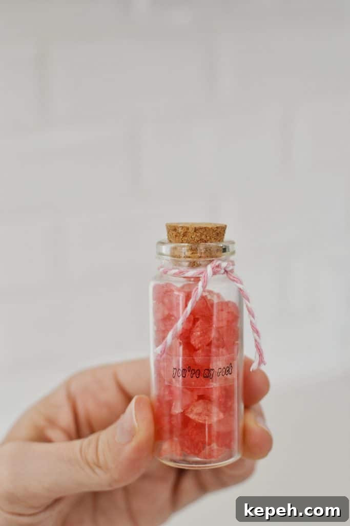 hands holding up a small valentine jar of candy