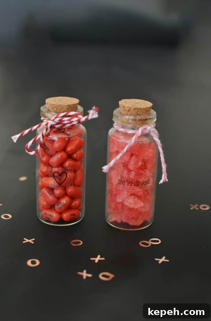 2 mini bottles of candy with ribbon around it