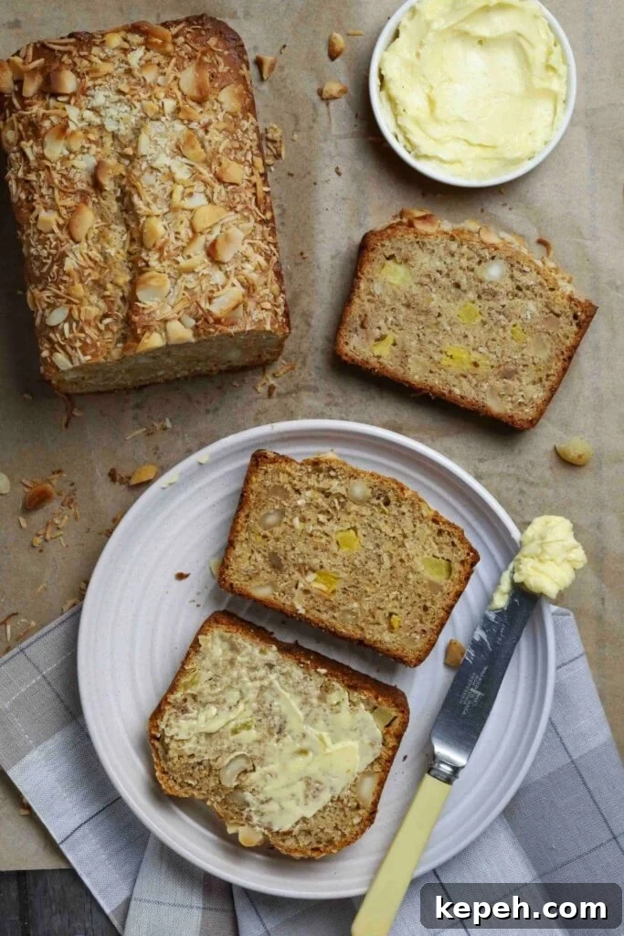 Sourdough Banana Bread with Hawaiian-Style Sweetness 3 Sourdough Hawaiian banana bread with two slices on a white plate next to a butter knife.