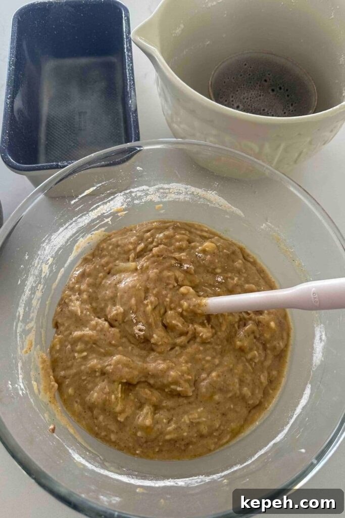 Sourdough Banana Bread with Hawaiian-Style Sweetness 8 Sourdough Hawaiian banana bread batter mixed together in a glass bowl with a spoon.