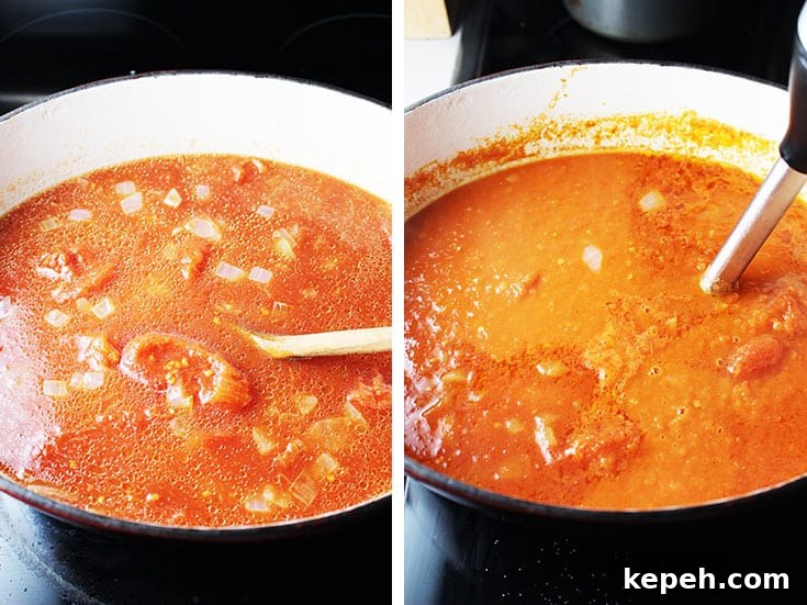 Tomato soup cooking in a dutch oven, and being blended with an immersion blender