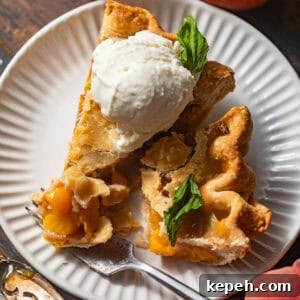 Perfect Peach Pie Recipe Using Canned Peaches 8 sliced peach pie on a plate topped with ice cream and mint.