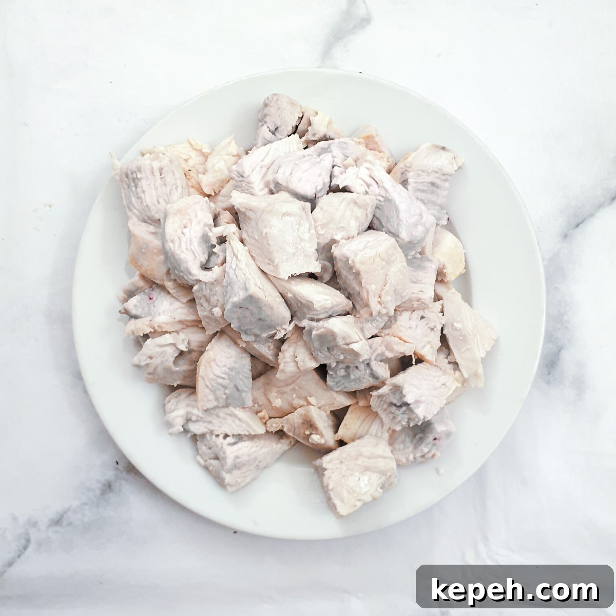 Classic Chicken à la King Recipe: Creamy One-Pot Dinner 7 A pile of cooked chicken pieces on a white plate.