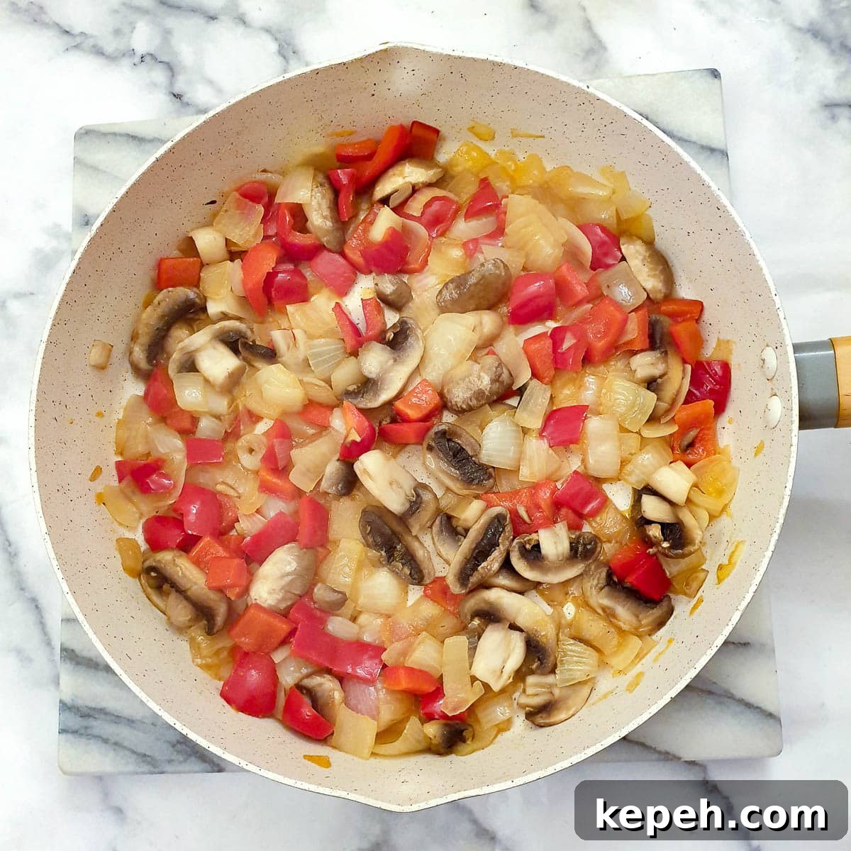 Classic Chicken à la King Recipe: Creamy One-Pot Dinner 9 Red pepper, onions and mushrooms being sauteed in a frying pa.